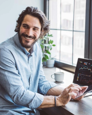 Ein Mann am Laptop, der sich einen Ueberblick im Aktienmarkt verschafft.